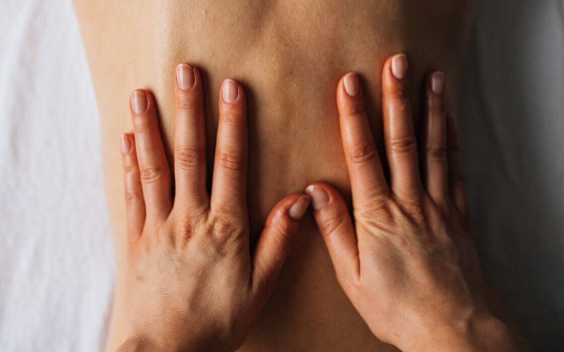 Gentle Swedish massage — flowing strokes on a client's back
